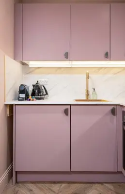a kitchen with white cabinets and a sink at Munro Guest House in Stirling