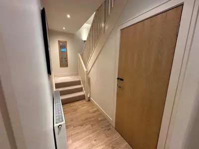 a hallway with a wooden door and stairs at Apartment Thistle Lane in Edinburgh