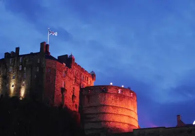 a castle with a flag on top of it at Castle Suite 1 Old Town in Edinburgh