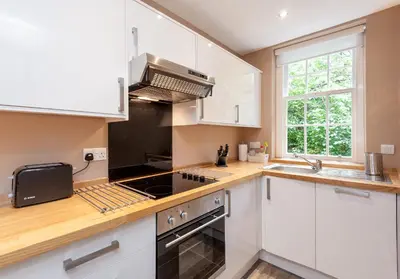 a kitchen with white cabinets and a stove top oven at Castle Suite 1 Old Town in Edinburgh