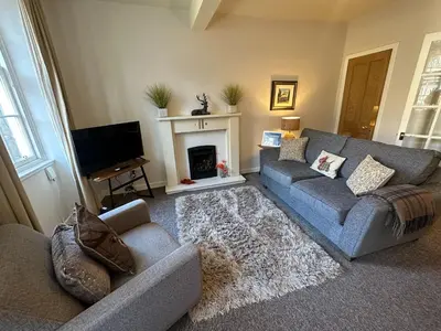 a living room with a couch and a fireplace at Castle Suite 3 Old Town in Edinburgh