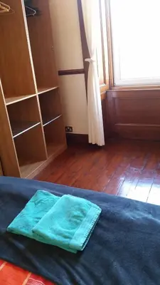 a green towel sitting on a bed in a room at Broompark House in Glasgow