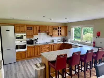 a kitchen with wooden cabinets and a white refrigerator at Wildwood Cottage with Hot Tub in Glencoe