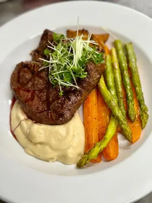 a plate of food with steak potatoes and vegetables at Loch Linnhe Waterfront Lodges with Hot Tubs in Glencoe