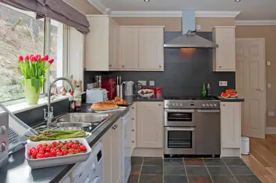 a kitchen with a sink and a stove top oven at Glenachulish Bay with Hot Tub in Glencoe