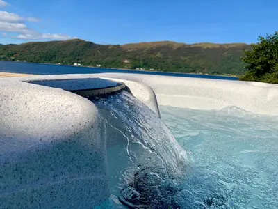a swimming pool with water coming out of it at Glenachulish Bay with Hot Tub in Glencoe