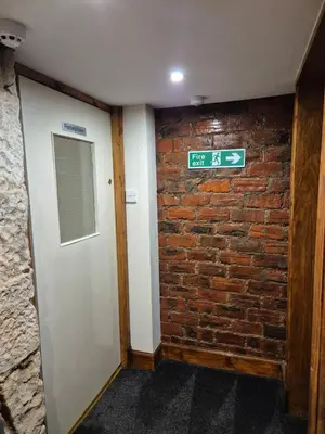 a brick wall with a door and a sign on it at Douglas Hotel in Glasgow