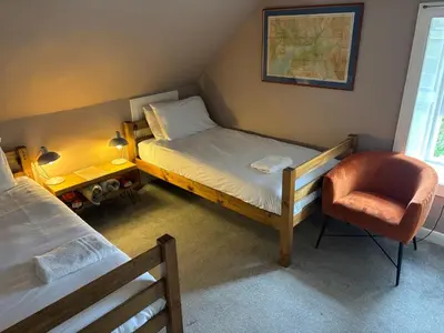 a small bedroom with a bed and a chair at Moffat Independent Hostel in Moffat
