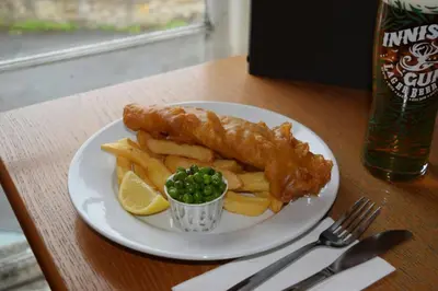 a plate of food with fish and chips and a lemon at The Stag Head Hotel in Edinburgh