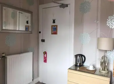 a kitchen with a white door and a table with a lamp at The Stag Head Hotel in Edinburgh