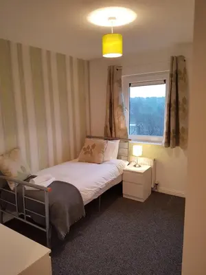 a small bedroom with a bed and a window at Bathgate Contractor and Business Apartment in Bathgate