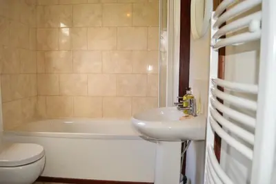 a bathroom with a sink and a tub and a toilet at Cockleshell Lodge in Otter Ferry
