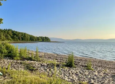 a beach next to a body of water at Cockleshell Lodge in Otter Ferry
