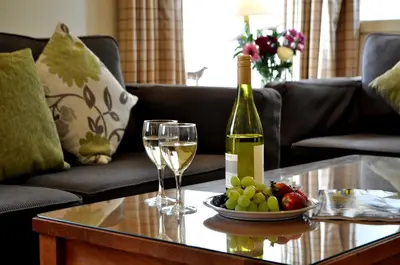 a bottle of wine and two glasses on a table at Melfort Village in Oban
