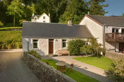 a house with a bench and a table in a yard at Melfort Village in Oban
