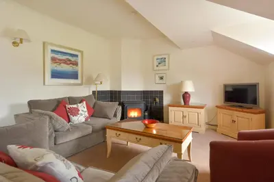 a living room with a couch and a fireplace at Melfort Village in Oban