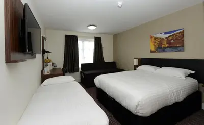 a hotel room with two beds and a couch at Highland Gate, Stirling by Marston's Inns in Stirling
