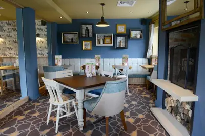 a dining room with blue walls and a table and chairs at Highland Gate, Stirling by Marston's Inns in Stirling