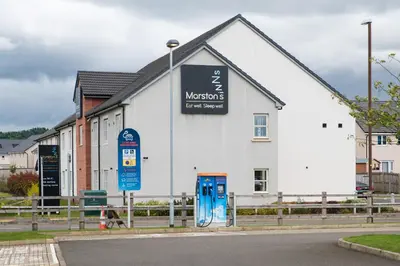 a white building with a sign on the side of it at Highland Gate, Stirling by Marston's Inns in Stirling