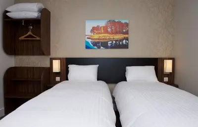 two beds in a room with white sheets at Chain Runner, Livingston by Marston's Inns in Livingston