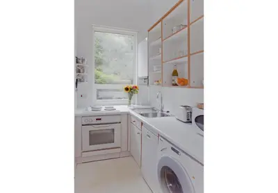 a white kitchen with a sink and a window at The Edinburgh Address - Classic Marchmont Charm in Edinburgh