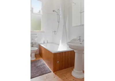 a bathroom with a white tub and a sink at The Edinburgh Address - Classic Marchmont Charm in Edinburgh