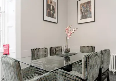 a dining room with a glass table and chairs at Edinburgh Castle Suite - The Edinburgh Address in Edinburgh