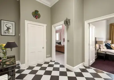 a room with a checkerboard floor and a room with a couch at Edinburgh Castle Suite - The Edinburgh Address in Edinburgh