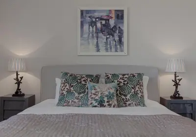 a bedroom with a bed with pillows and two lamps at The Skyline - The Edinburgh Address in Edinburgh