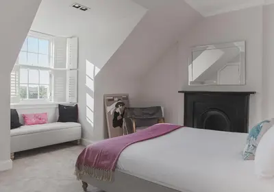 a white bedroom with a bed and a couch at The Skyline - The Edinburgh Address in Edinburgh