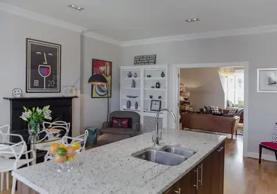 a kitchen with a sink and a living room at The Skyline - The Edinburgh Address in Edinburgh