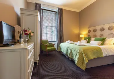 a hotel room with a bed and a television at The Edinburgh Address - Castle View Apartment in Edinburgh