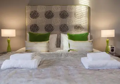 a bedroom with a large bed with green and white pillows at The Edinburgh Address - Castle View Apartment in Edinburgh