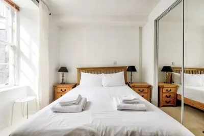 a bedroom with a white bed with two towels on it at Rose Street - Watchmakers Apartment in Edinburgh