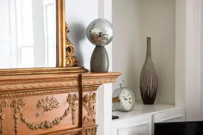 a mirror sitting on top of a table with a vase at Rose Street - Watchmakers Apartment in Edinburgh