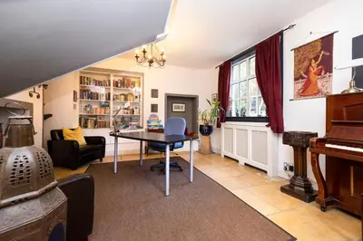 a living room with a table and a piano at Strathendrick House Magnificent property with Garden in Drymen