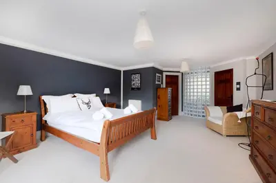 a bedroom with a large bed and a couch at Strathendrick House Magnificent property with Garden in Drymen
