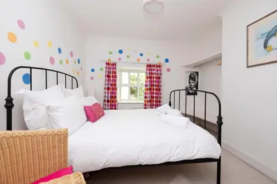 a bedroom with a large white bed with a black frame at Strathendrick House Magnificent property with Garden in Drymen