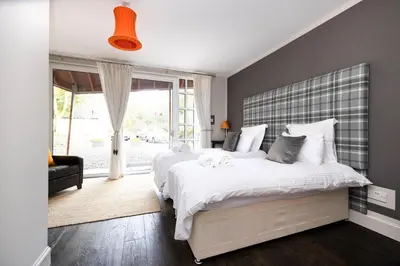 a bedroom with a large white bed and a window at Strathendrick House Magnificent property with Garden in Drymen