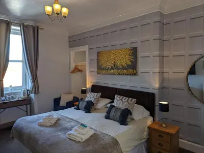 a bedroom with a bed with towels on it at Brig O'Doon Guest House in Edinburgh