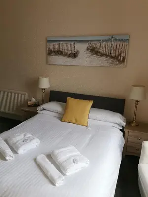 a bedroom with a bed with towels on it at Brig O'Doon Guest House in Edinburgh