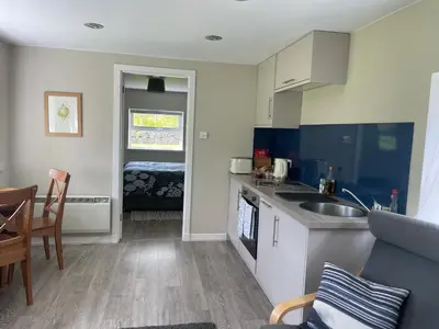 a small kitchen with a sink and a table at Woodside Cottage Self Catering in Kinbuck