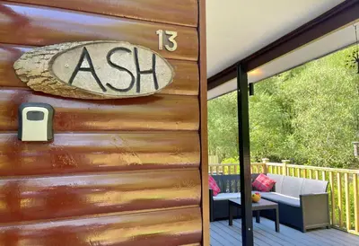 a wooden door with a ash sign on a deck at Ash Lodge in Benmore