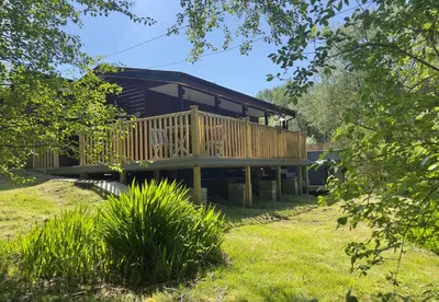 a house with a deck with people on it at Ash Lodge in Benmore
