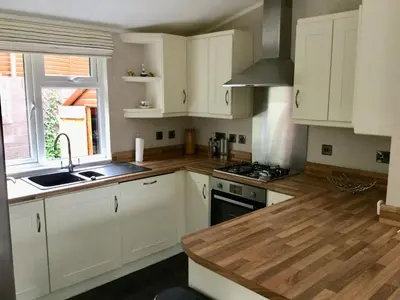 a kitchen with white cabinets and a sink at Rannoch Lodge in Auchterarder