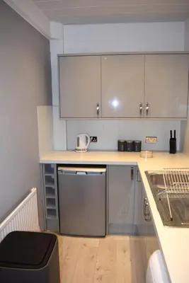 a kitchen with a sink and a counter with a dishwasher at Kelpies Serviced Apartments - Wallace in Falkirk