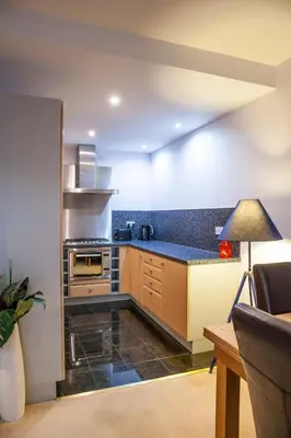 a kitchen with wooden cabinets and a blue counter top at Riverside West End Apartment in Glasgow