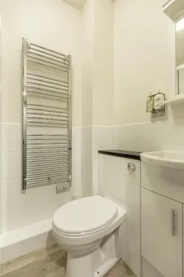 a white bathroom with a toilet and a sink at The Wee Thistle in Edinburgh
