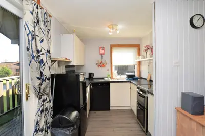 a small kitchen with a sink and a stove at Holy Loch Lodge in Hunters Quay