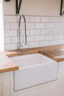 a white kitchen with a sink at Dunruadh Cottage in Gartocharn